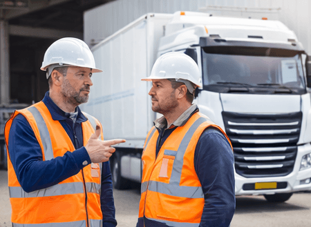 Chauffeurs en tenue de sécurité devant un camion – équipes formées B2B